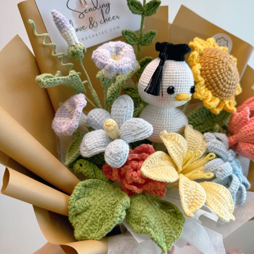 Crocheted flowers and a small plush toy resembling a duck on a white background