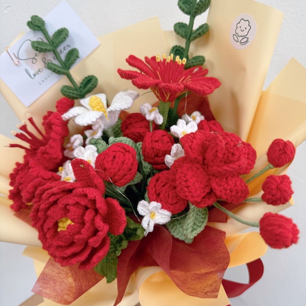 Bouquet of red and white flowers made from yarn on a yellow background