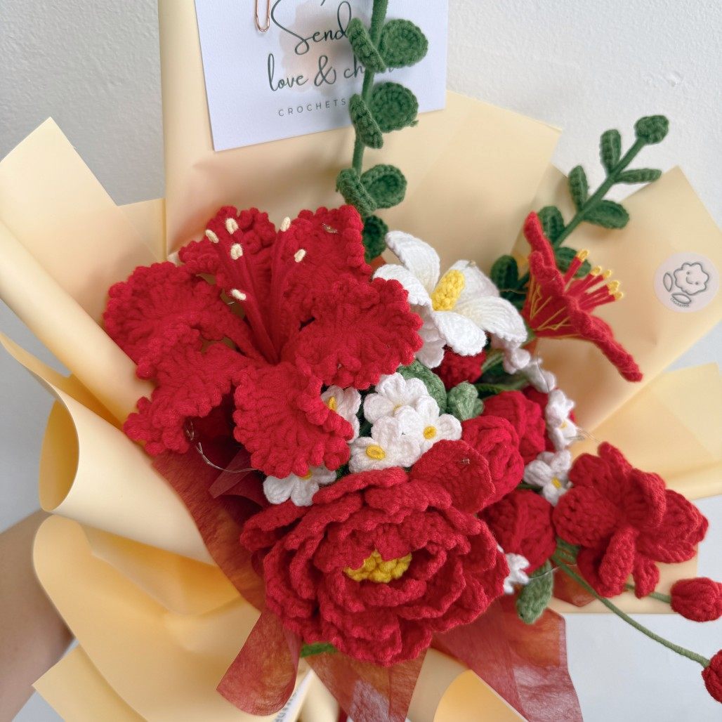 Crocheted bouquet with red and white flowers on yellow paper