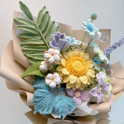 Crocheted flower bouquet with colorful flowers and leaves on a light background