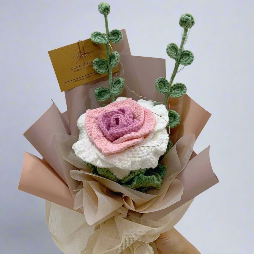 A bouquet with large crochet rose in the middle and 2 crochet eucalyptus leaves